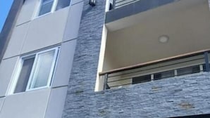 Ein mehrgeschossiges Gebäude mit großen Fenstern und einer strukturierten Fassade.