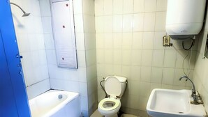 A bathroom with a bathtub, toilet, and sink. - OASIS Hotel Downtown (Cairo)