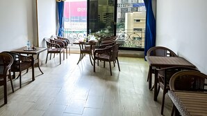 Zona pranzo con mobili in legno e vista sulla città attraverso ampie finestre.