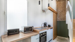 A compact kitchen with a toaster, microwave, coffee maker, and a sink. - Superior Suite - Open Space (Sevilla)