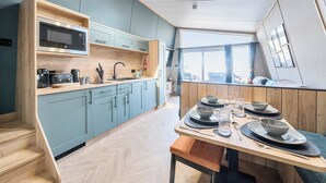 Una cucina moderna con forno a microonde, tostapane e macchina del caffè sul piano di lavoro, un lavello e una finestra con vista sulla città.