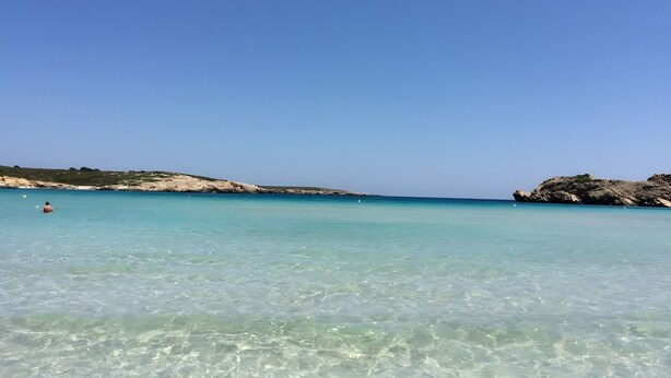A clear beach with calm waters and rocky outcrops. - Villa 'Mottarone Cerca De Mar' with Private Pool, Wi-Fi and Air Conditioning (Sant Lluís)