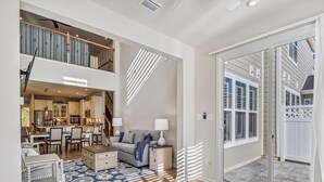 A spacious living area with a dining table, sofa, and a view of the kitchen.