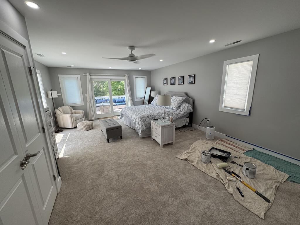A bedroom with a bed, nightstands, a chair, and a window.
