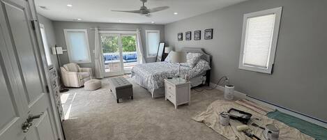 A bedroom with a bed, nightstands, a chair, and a window.