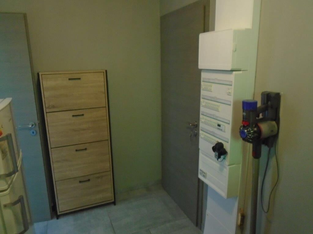 Ein Zimmer mit einem Holzkasten, einer Tür und einem an der Wand befestigten Gerät mit Papier.