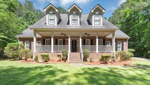 A two-story house with a front porch, a covered entryway, and a symmetrical roofline.