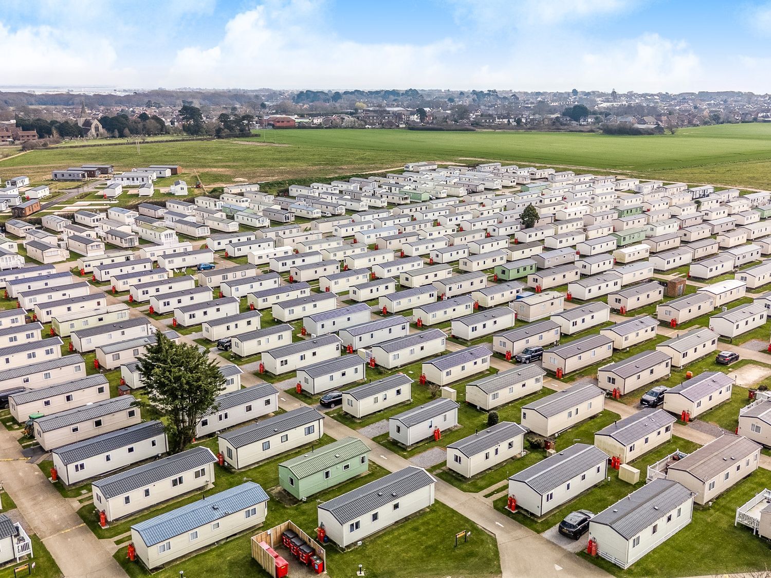 Un extenso parque para caravanas con numerosas caravanas dispuestas en filas.