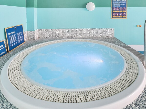 A hot tub with a tiled edge, surrounded by a pool area with a blue and white tiled floor. - The Lookout - Hayling Island (Hayling Island)