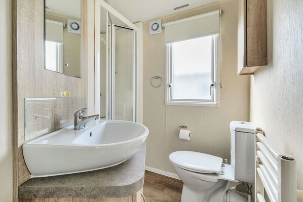 Une salle de bain avec une baignoire sur pieds, des toilettes et une fenêtre.