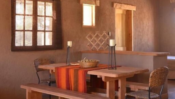 A rustic dining area with a wooden table, benches, and chairs. - HOSTAL VALLE DE LA LUNA  (Antofagasta)