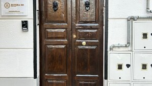 A double wooden door with a metal gate above, a mailbox, and a utility box with numbered compartments. - Butera505luxurysuites (Bagheria)