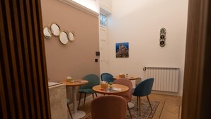 A dining area with a round table, chairs, and a patterned rug. - Butera505luxurysuites (Bagheria)