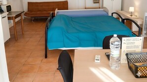 Ein Hotelzimmer mit Bett, Schreibtisch, Stuhl, Fernseher, Kleiderschrank und Bad.