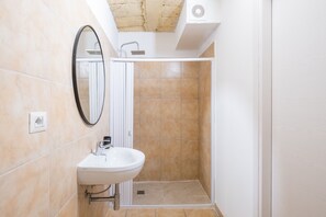 Ein Badezimmer mit Waschbecken, Spiegel und Duschbereich.