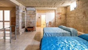 Une pièce avec un lit, un bureau et une chaise. Il y a une fenêtre et une porte.