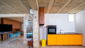 Une cuisine compacte dotée d’un four et d’un évier intégrés, d’un meuble en bois et d’une petite fenêtre.