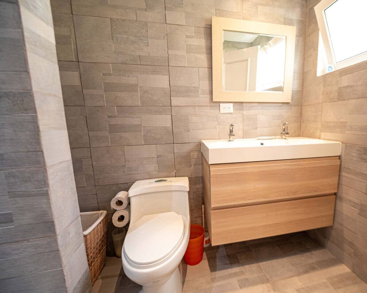 Une salle de bain avec des toilettes, un lavabo et un miroir.