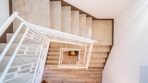 A spiral staircase with a white railing, beige steps, and a small decorative item at the bottom. - Apartment 'Ognissanti' with Private Terrace, Wi-Fi and Air Conditioning (Ragusa)