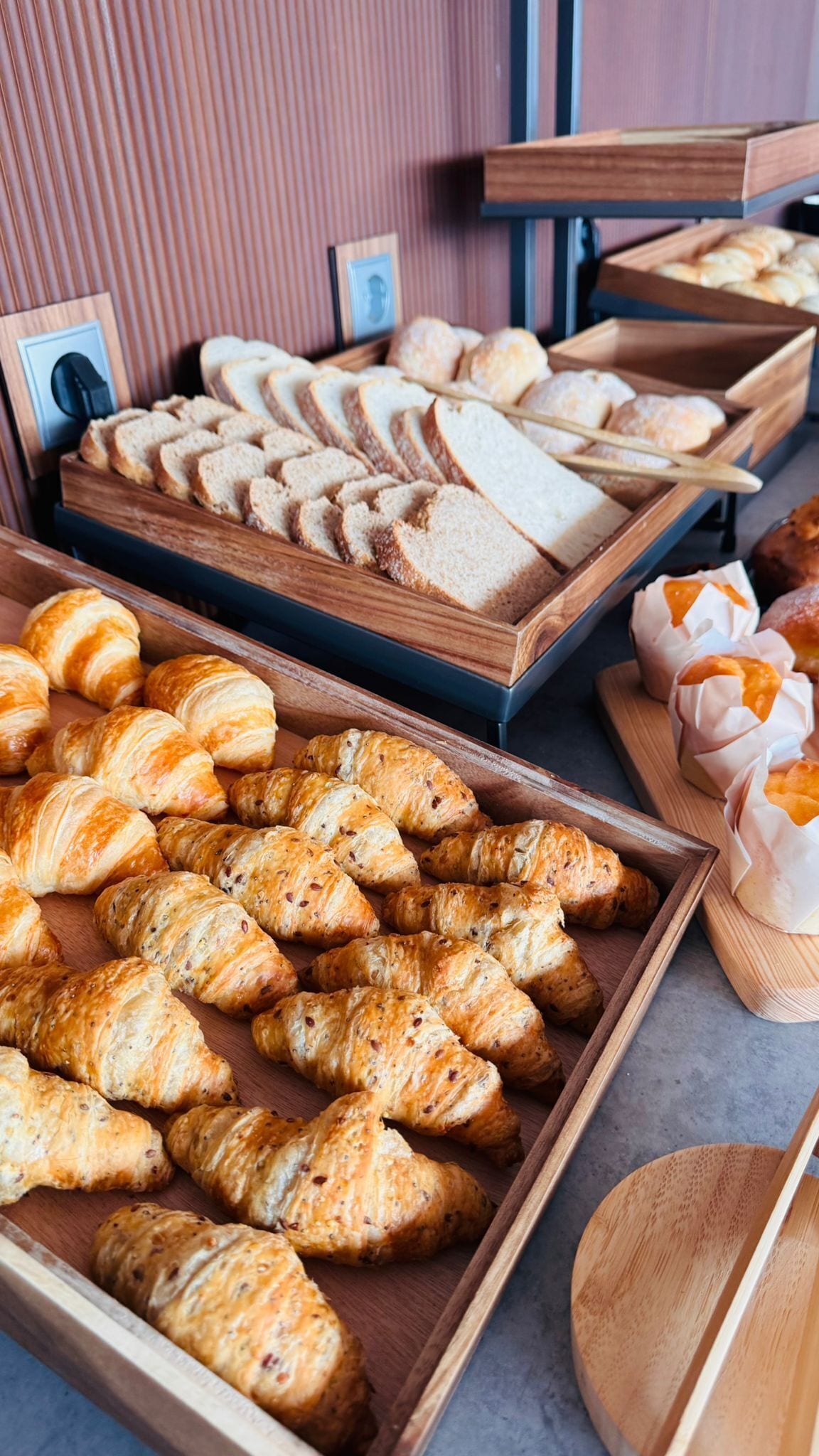 A bakery display with various types of bread and pastries.