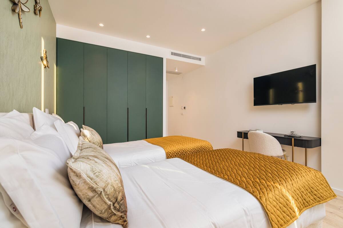 Une chambre d’hôtel moderne équipée d’un lit, d’un bureau et d’une télévision.