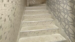 A staircase with patterned walls and a patterned wall at the bottom.