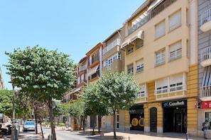 A street with buildings, trees, and a bank.