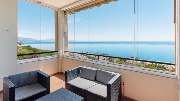 A balcony with a view of the sea, wicker furniture, and a clear sky. - Apartment 'Panoramic Sea Views' with Sea View, Wi-Fi and Air Conditioning (Manilva)