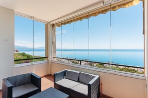 A balcony with a view of the sea, wicker furniture, and a clear sky. - Apartment 'Panoramic Sea Views' with Sea View, Wi-Fi and Air Conditioning (Manilva)