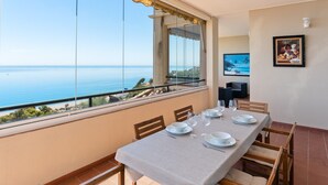 A dining area with a table set for four, overlooking a coastal view. - Apartment 'Panoramic Sea Views' with Sea View, Wi-Fi and Air Conditioning (Manilva)