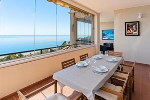 A dining area with a table set for four, overlooking a coastal view. - Apartment 'Panoramic Sea Views' with Sea View, Wi-Fi and Air Conditioning (Manilva)