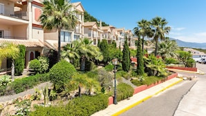 A residential area with multi-story buildings, palm trees, and a clear sky. - Apartment 'Panoramic Sea Views' with Sea View, Wi-Fi and Air Conditioning (Manilva)