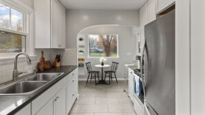 A modern kitchen with white cabinetry, a stainless steel sink, and a built-in oven.