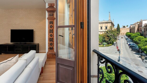 A modern living room with a large TV, a sofa, and a wooden accent wall. - Genteel Home Tomás de Ibarra IV (Seville)