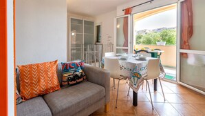 A balcony with a dining table, chairs, and a sofa with decorative pillows. - Vacation Home 'Mare Nostrum' with Mountain View, Private Terrace, and Air Conditioning (Castelsardo)