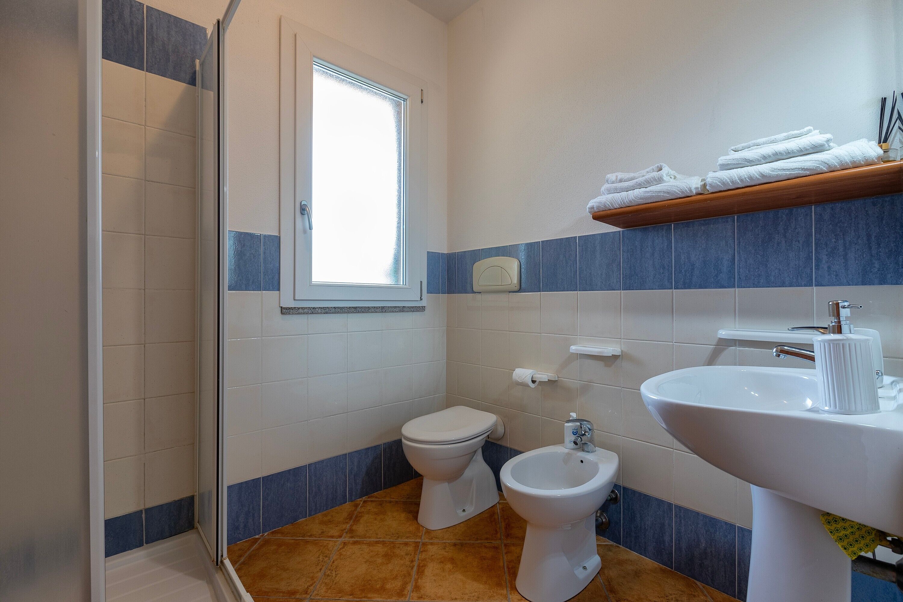 Ein Badezimmer mit Dusche, Toilette, Bidet und Waschbecken.