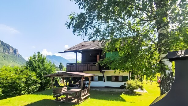 Un chalet doté d’une terrasse en bois et offrant une vue sur les montagnes.