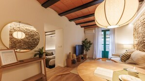 Een gezellig eetgedeelte met een ronde houten tafel, een spiegel en een hanglamp.