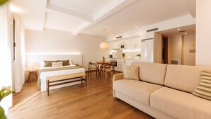 Une chambre d’hôtel moderne dotée d’un grand lit, d’un canapé, d’un coin repas et d’une kitchenette.