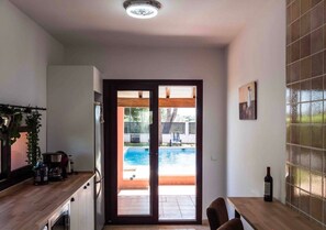 Cocina con vista a una piscina a través de un ventanal.
