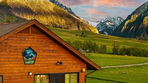 A wooden cabin with a balcony overlooking a green valley and mountains. - Spacious home with mountain and valley views, seconds to Deep Creek trailhead (Livingston)