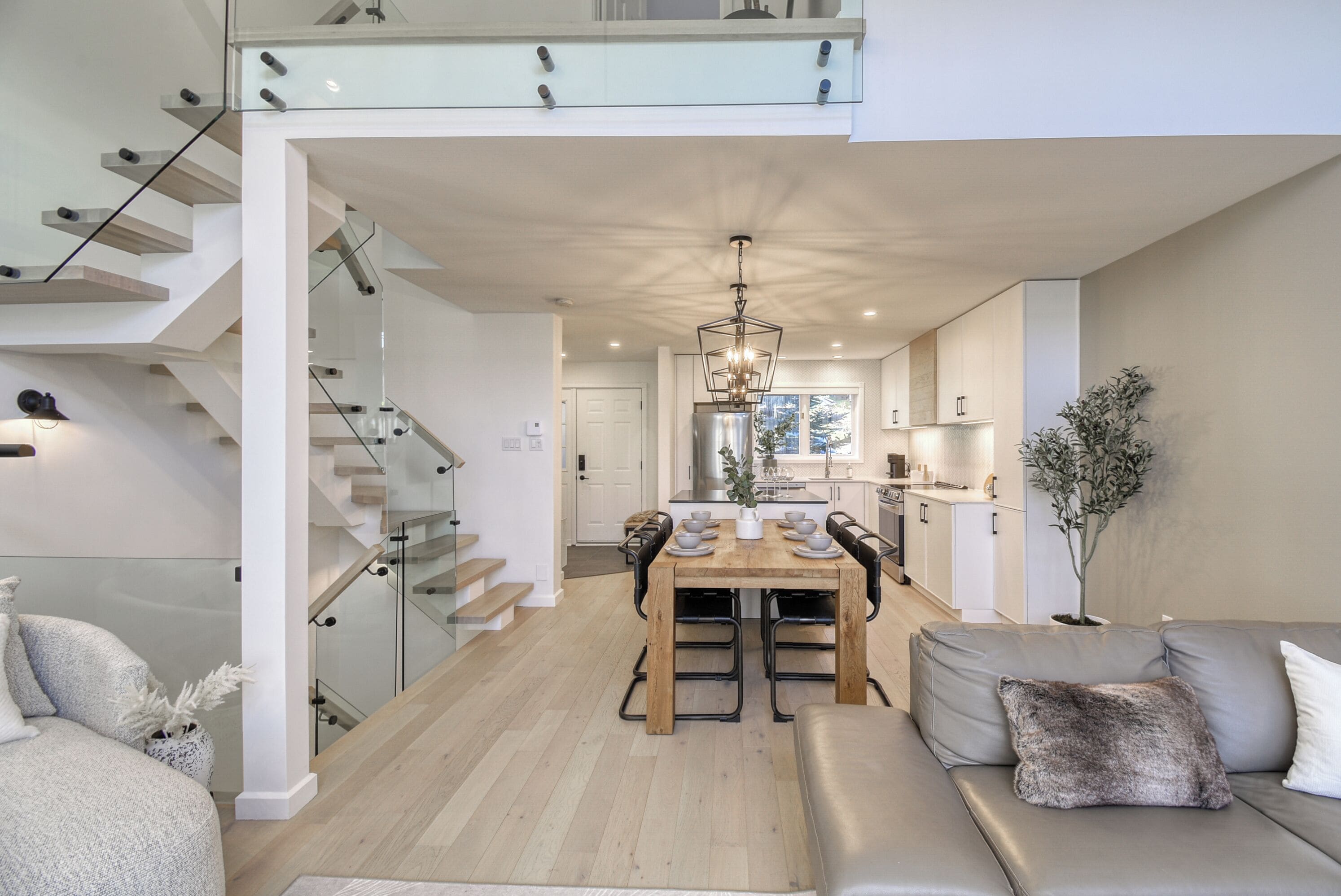 Un interior moderno con escalera, comedor y zona de estar.