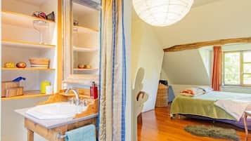 Une chambre avec un plafond en pente, une grande fenêtre, un lit et un plancher en bois.