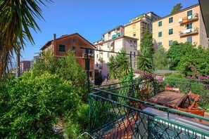 A residential area with multi-story buildings, balconies, and lush greenery.