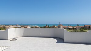 A rooftop terrace with a view of the sea and buildings. - Villa 'Primavera' with sea view, private terrace and air conditioning (Marina di Modica)