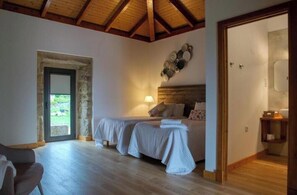 Cozy bedroom with rustic charm, featuring two beds, a bedside table, and a wall-mounted shelf.