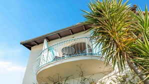 Un edificio con un balcone dotato di ringhiera metallica e un piccolo angolo relax.