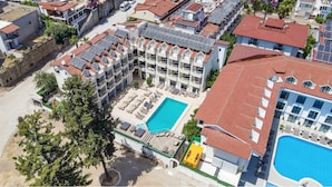 Un hôtel à plusieurs étages doté d’une piscine sur le toit et de panneaux solaires.