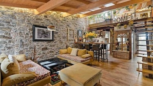 A rustic interior with stone walls, wooden beams, a bar area, and a sofa set. - My Home, Welcome Way (Riomaggiore)