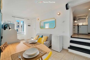 A compact living space with a dining area, kitchenette, and a view of the outside. - The Echo in the Rock, Welcome Way (Vernazza)